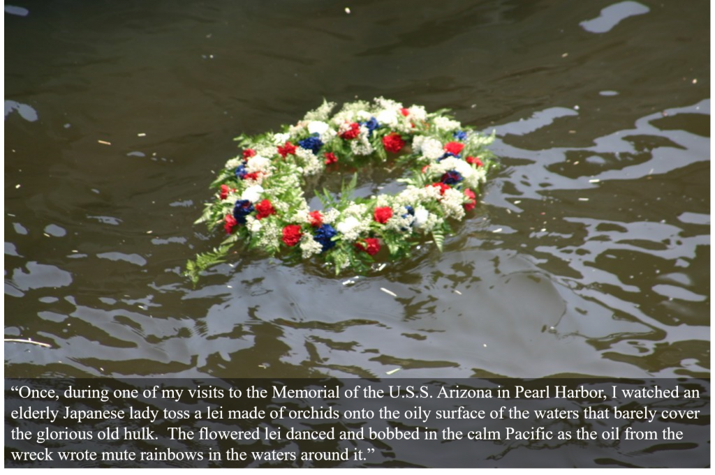A Flowered Lei Bobs In the Water of Pearl Harbor Over the Sunken Wreck of the USS Arizona.
